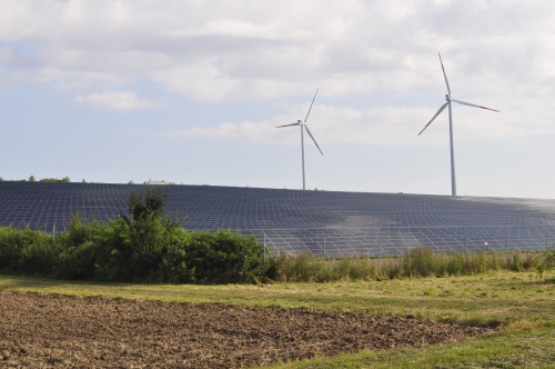 突如として現れる”ソーラーパネル畑”と風力発電の風車。